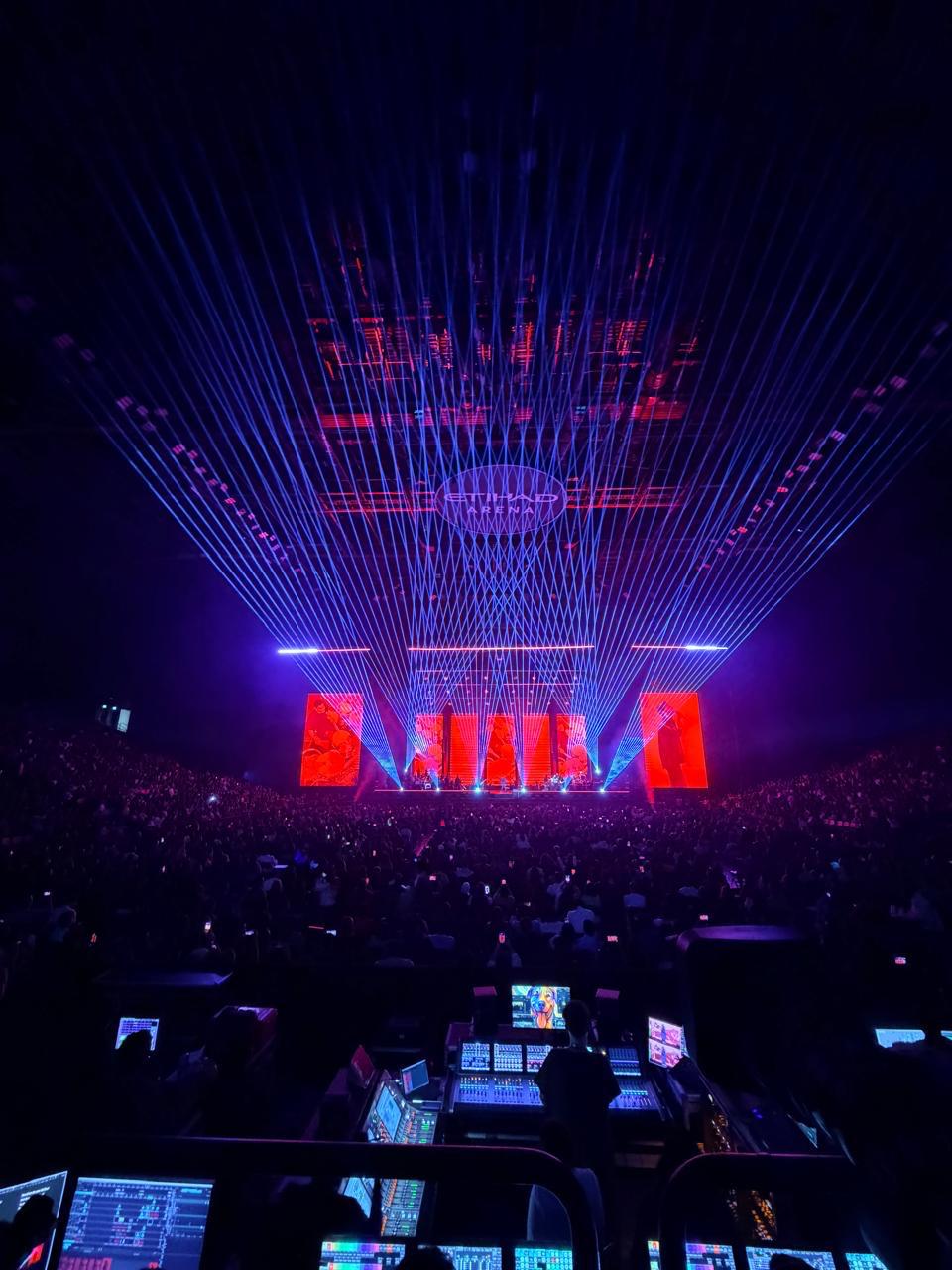 Large arena concert with laser lighting and control desks